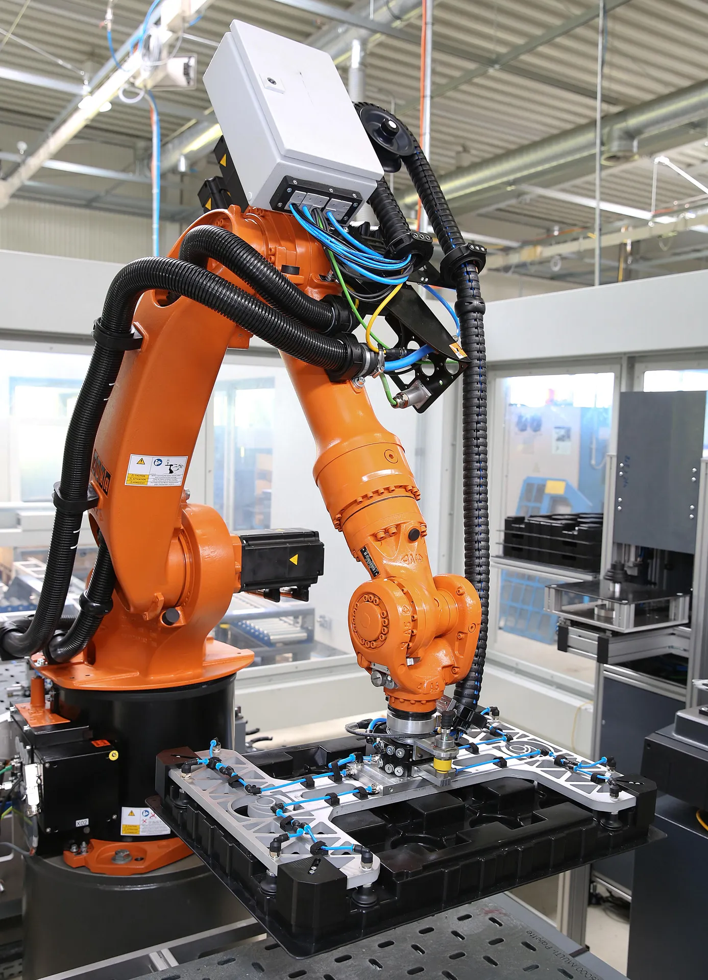Roboter mit Vakuumgreifer und Kunststoffwarenträger