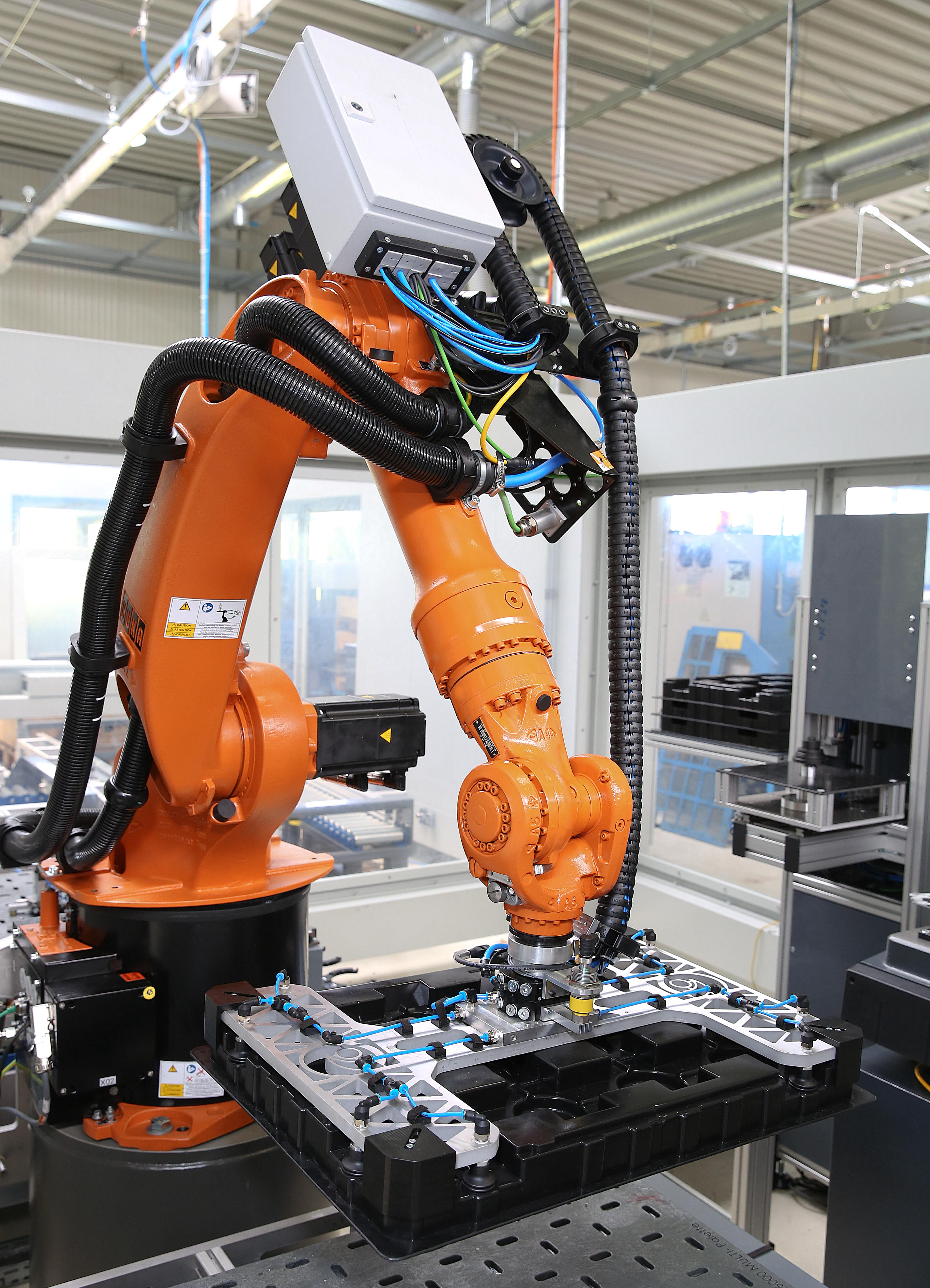 Roboter mit Vakuumgreifer und Kunststoffwarenträger