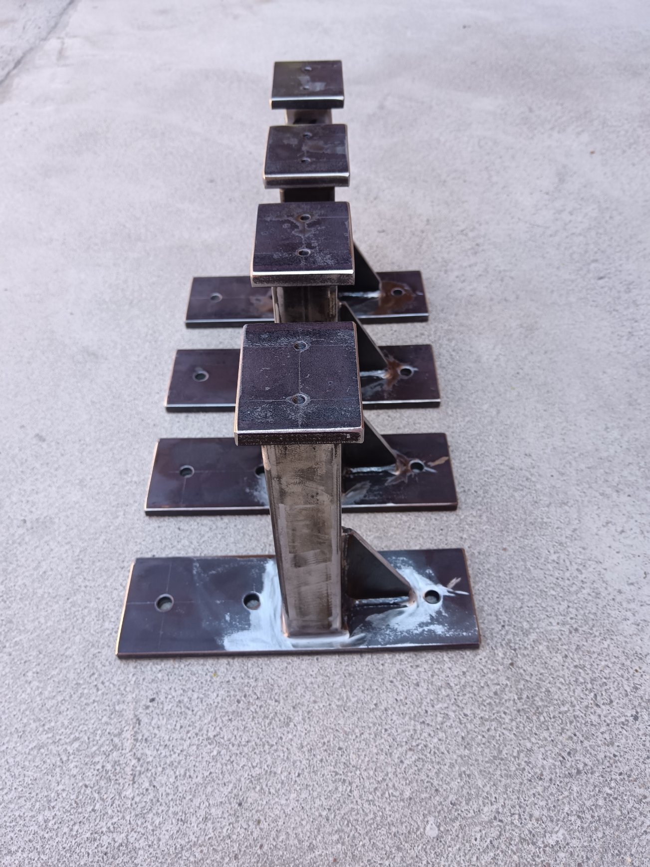 Example of welded mild-steel support brackets / mounting posts produced in small batch. The parts consist of rectangular hollow sections, drilled base plates and top plates, welded by MIG/MAG process. Such components can be used as equipment supports, mounting brackets, auxiliary machine-frame elements or prototype support structures. Production can be carried out according to customer drawings or technical documentation.