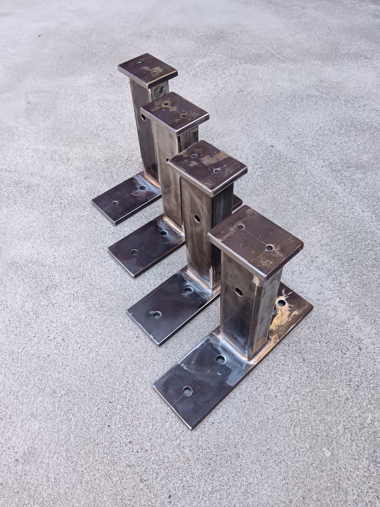 Example of welded mild-steel support brackets / mounting posts produced in small batch. The parts consist of rectangular hollow sections, drilled base plates and top plates, welded by MIG/MAG process. Such components can be used as equipment supports, mounting brackets, auxiliary machine-frame elements or prototype support structures. Production can be carried out according to customer drawings or technical documentation.